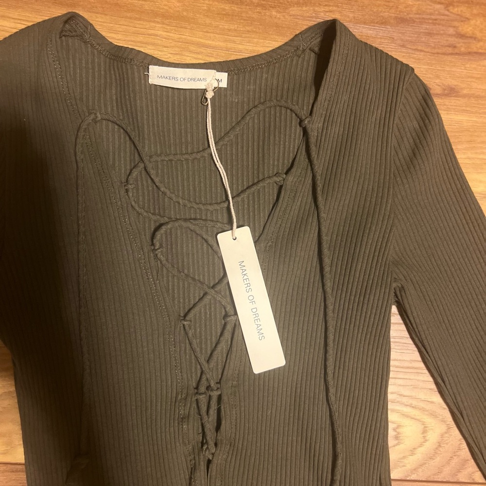 Long sleeve body suit with very low mid drift that ties down the front